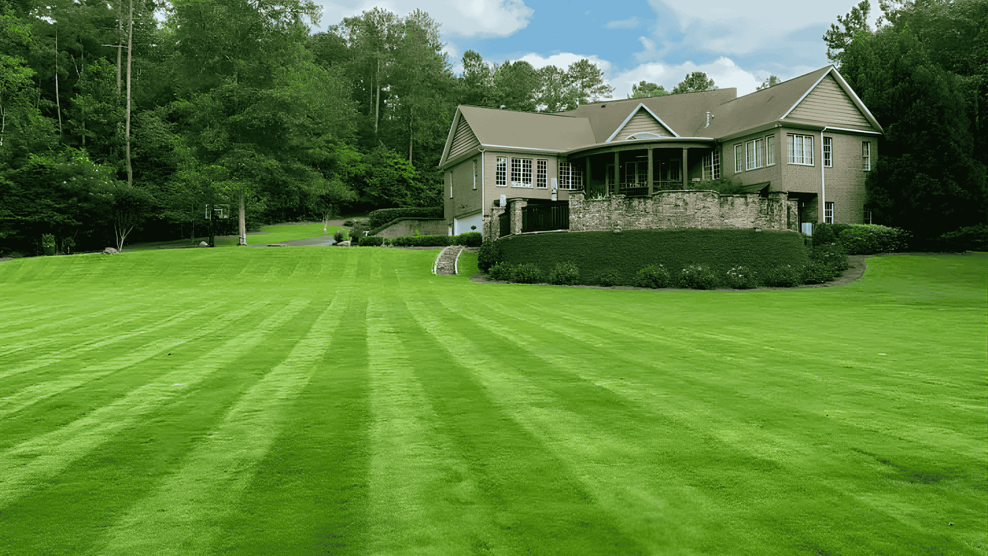 Crew from Cutting Edge Landscaping, LLC mowing and trimming a residential lawn in Milledgeville, GA on a sunny morning