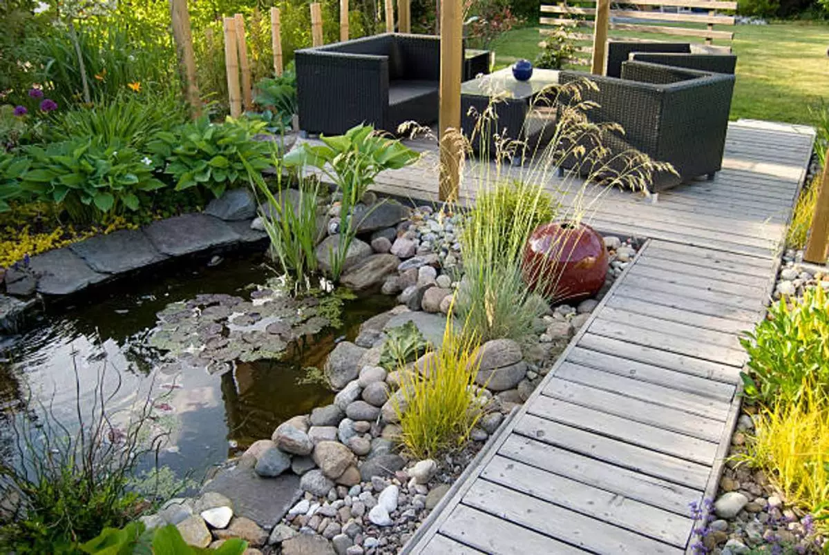 Experienced landscaper inspecting plant beds and lawn health with professional equipment