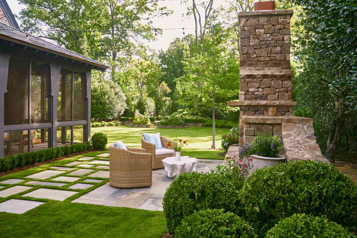 Crew building a custom stone patio and outdoor kitchen in a Milledgeville, GA backyard surrounded by mature trees